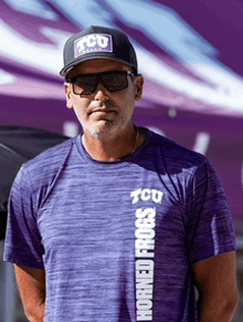 a man wearing a horned frogs shirt and a hat