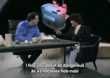 two men are sitting at a table and one of them says i find you about as dangerous as a chocolate hob-nob!