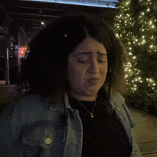a woman in a denim jacket says " you " in pink