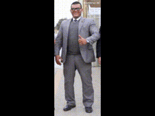 a man in a suit is holding a gun in his right hand