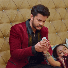a man in a red jacket holds the hand of a woman