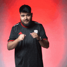 a man with a beard wears a black adidas shirt