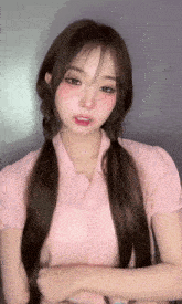 the girl is wearing a pink shirt and pigtails and has a pink shirt on .