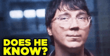 a close up of a man wearing glasses with the words " does he know " on the bottom