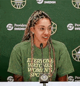 a woman is sitting at a table with a microphone in front of her .