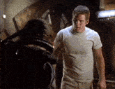 a man in a white shirt is standing next to another man in a black jacket