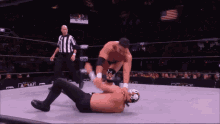 two men are wrestling in a ring with a referee and a tbs logo