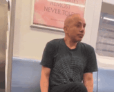 a man is sitting on a train with a poster that says almost never told