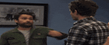 two men are fighting in front of a picture of a man riding a skateboard