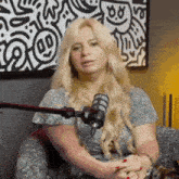 a woman is sitting in front of a microphone with a smiley face on her face