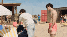 a man without a shirt is standing next to another man