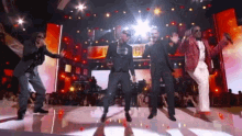 a group of men are dancing on a stage in front of a crowd with a sign that says ' u.s. '