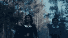 a group of young girls are running through a forest .