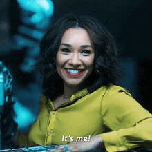 a woman in a yellow shirt smiles and says " it 's me "