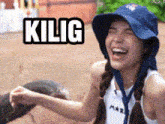 a woman wearing a blue hat is laughing and holding an ostrich .