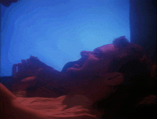 a man is laying down with his mouth open in front of a blue background