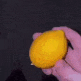 a person is holding a lemon in their hands