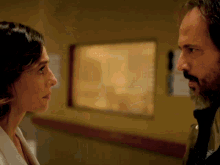 a man and woman looking at each other in a hallway