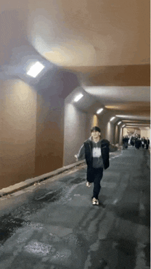 a person is running through a tunnel with a group of people walking behind them .