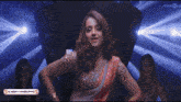 a woman in a saree is dancing in front of a think music logo