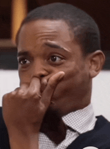 a close up of a man covering his face with his hand