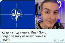 a man with a shaved head is smiling in front of a blue flag with the nato logo on it