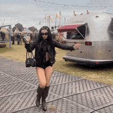 a woman standing in front of an airstream trailer