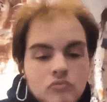 a close up of a woman 's face with her eyes closed and earrings on