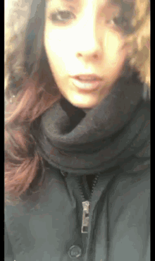 a woman wearing a black scarf and a black jacket