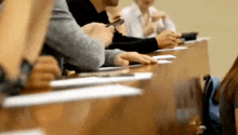 a group of people are sitting at a long table in a classroom .