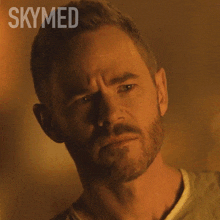 a close up of a man 's face with the word skymed written above him