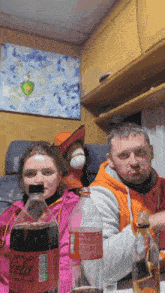 a man and a woman sit at a table with a bottle of coca cola in front of them