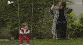 a man is sitting on a swing next to a little girl with a hd logo on the bottom