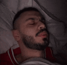 a man with a beard covering his face with his hands