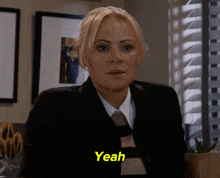 a woman in a suit and tie says yeah in yellow letters