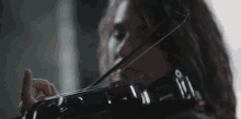 a woman with long hair is playing a violin in a dark room .