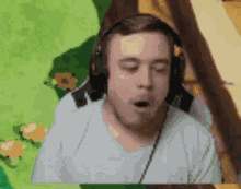 a man wearing headphones is making a funny face with his mouth open .