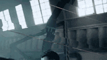a man is standing in a dark room with a lot of windows behind him
