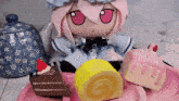 a stuffed doll with pink eyes sits next to a plate of cakes on a table