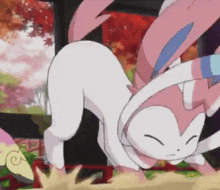 a pink and white pokemon is laying down on the ground