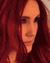a close up of a woman 's face with red hair and green eyes