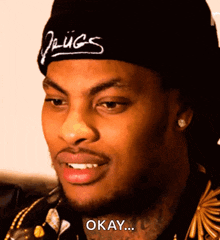 a man wearing a beanie with the word drugs on it