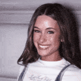 a woman wearing a white shirt that says margaritosgif smiles for the camera