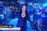 a female wrestler is walking into a crowded stadium on saturday june 7