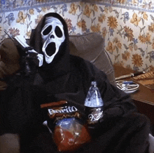 a person wearing a scream mask is sitting on a couch holding a bag of doritos and a bottle of pepsi
