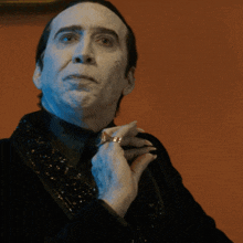 a man with white paint on his face is wearing a ring