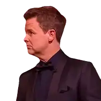 a man in a tuxedo with a bow tie looks to his left
