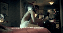 a shirtless man is laying on a bed in a room