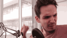 a man making a funny face while standing in front of a microphone