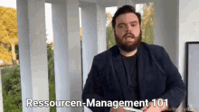 a man with a beard is holding a piece of paper and says resourcen-management 101